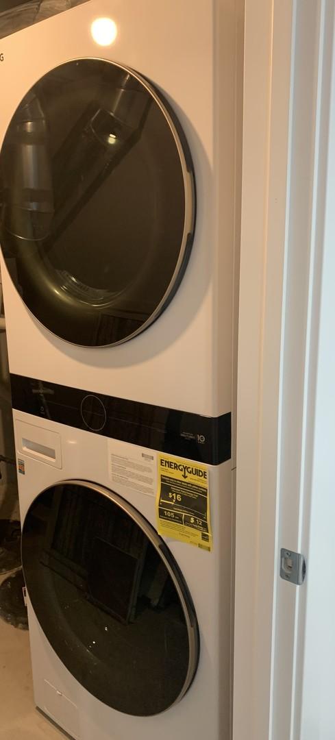 clothes washing area with stacked washer and dryer