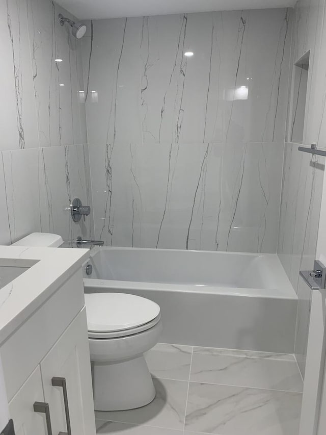 full bathroom featuring vanity, tiled shower / bath combo, and toilet