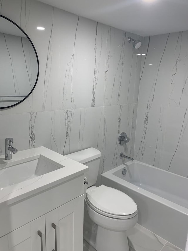 full bathroom featuring vanity, toilet, tiled shower / bath combo, and tile walls