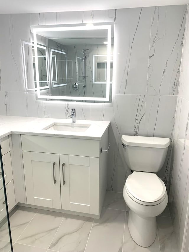 bathroom with vanity, a shower, and toilet