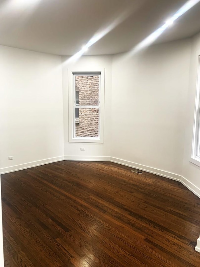 empty room featuring dark hardwood / wood-style flooring