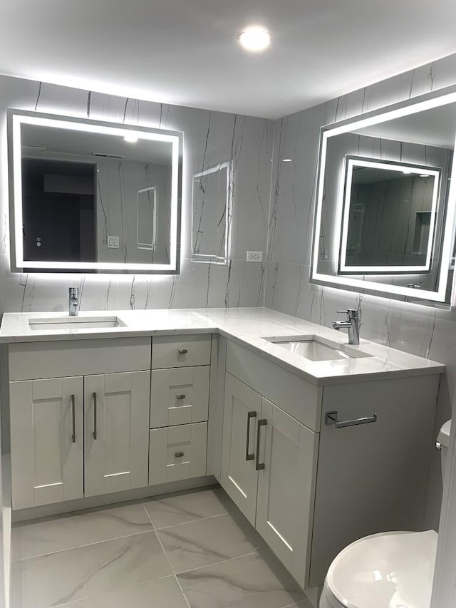 bathroom featuring tasteful backsplash, vanity, toilet, and tile walls