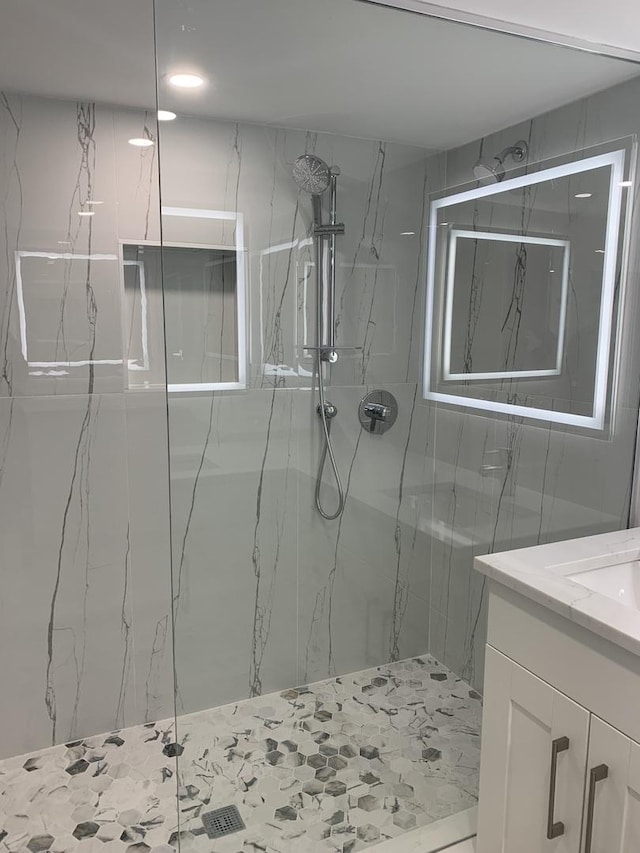 bathroom with vanity and a tile shower