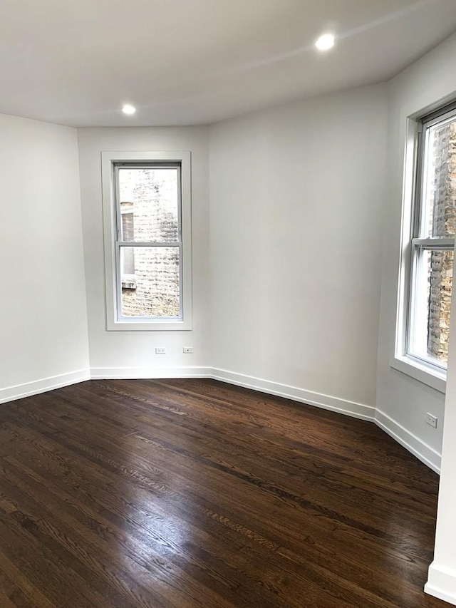 unfurnished room with dark wood-type flooring