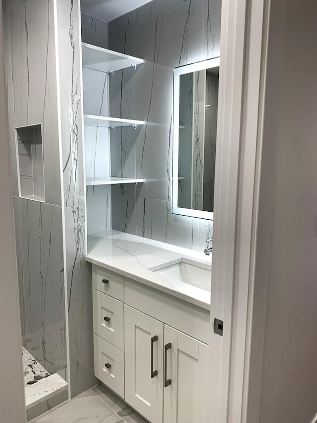 bathroom with vanity and a shower