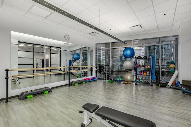 workout area featuring hardwood / wood-style flooring and a paneled ceiling