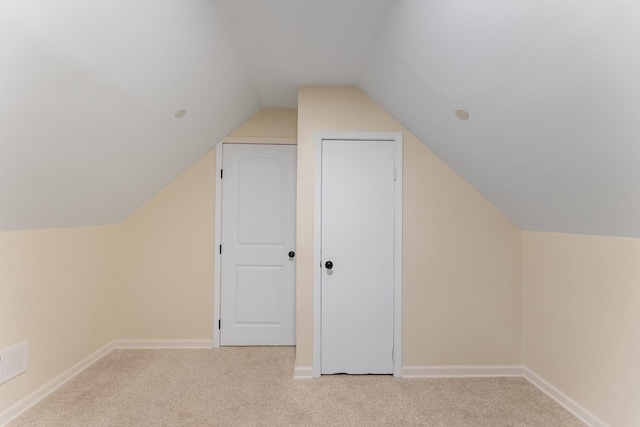 bonus room featuring vaulted ceiling and light colored carpet