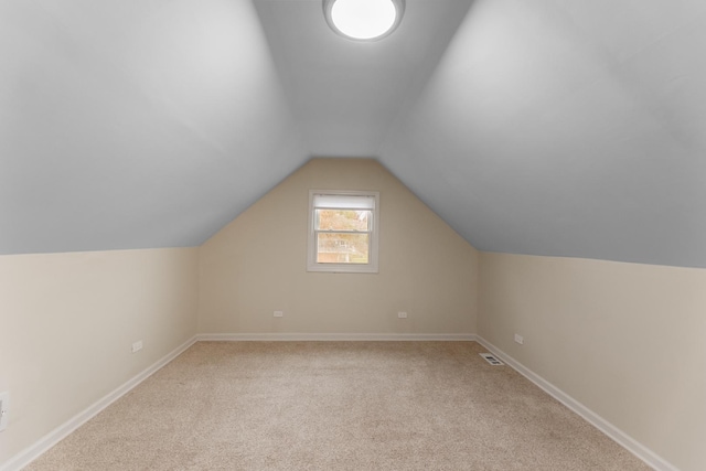 additional living space with light carpet and vaulted ceiling