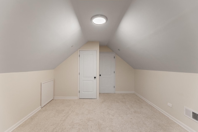 additional living space with light colored carpet and lofted ceiling