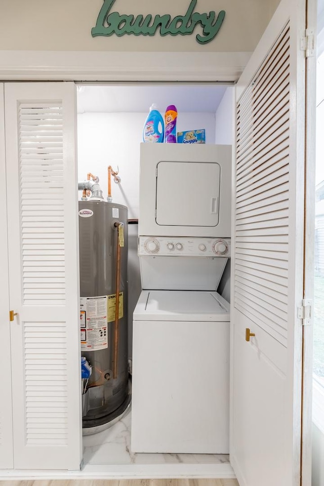 laundry room with stacked washer / drying machine and gas water heater