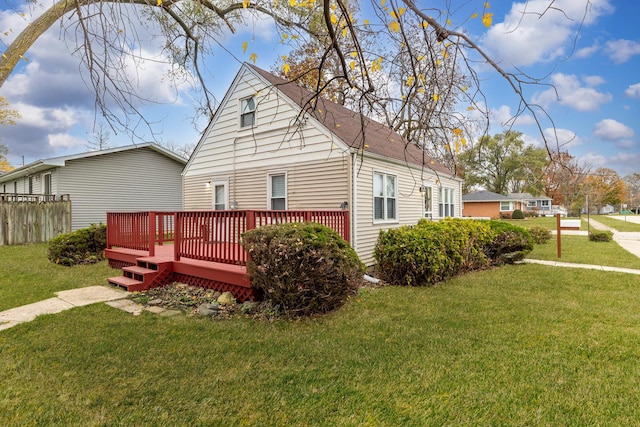 rear view of property with a wooden deck and a lawn