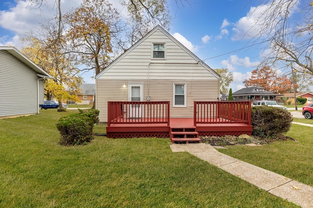 rear view of house featuring a yard and a deck