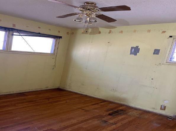 spare room featuring a textured ceiling, ceiling fan, and dark hardwood / wood-style flooring