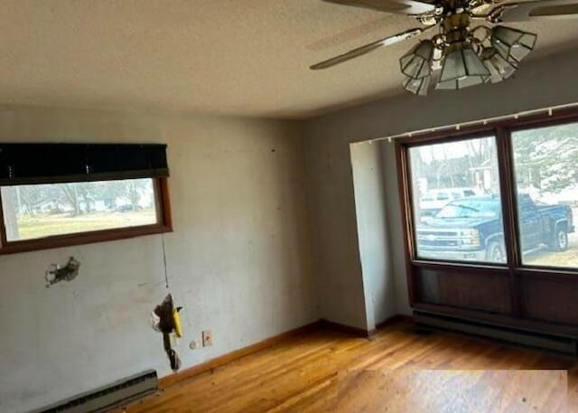 spare room with light hardwood / wood-style floors, ceiling fan, a textured ceiling, and a baseboard radiator