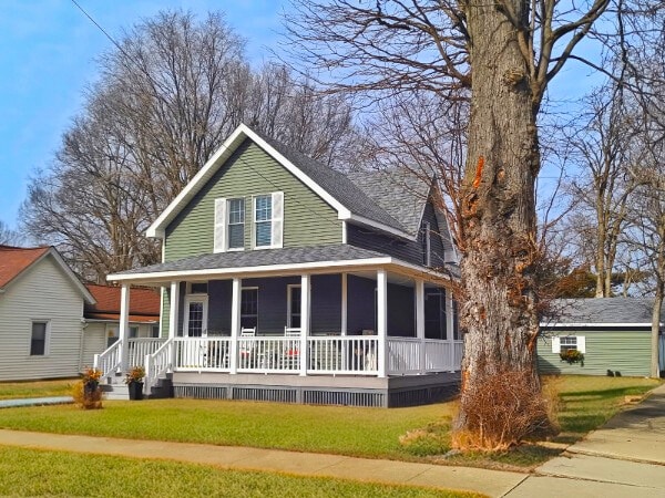 farmhouse featuring a porch and a front yard