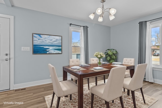 dining space with an inviting chandelier and light hardwood / wood-style floors