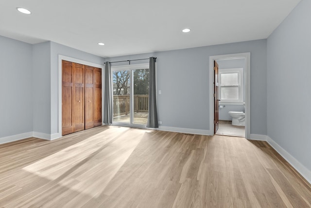 unfurnished bedroom with multiple windows, access to outside, a closet, and light hardwood / wood-style flooring