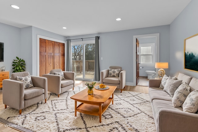 living room featuring a healthy amount of sunlight and light hardwood / wood-style flooring