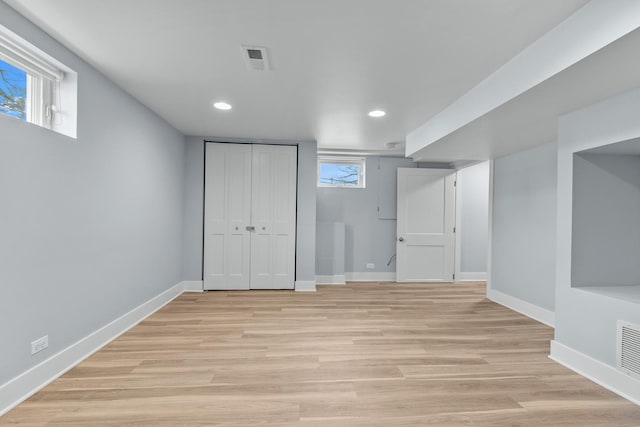 basement featuring a healthy amount of sunlight and light wood-type flooring