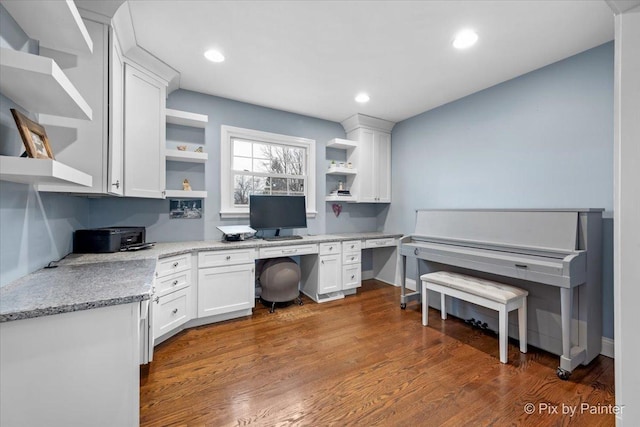 office space with dark hardwood / wood-style flooring and built in desk