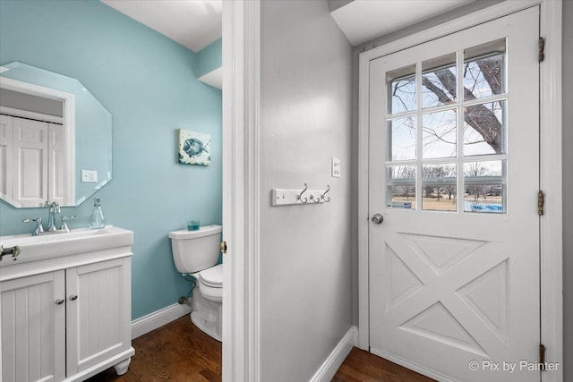 bathroom featuring wood-type flooring, toilet, and vanity