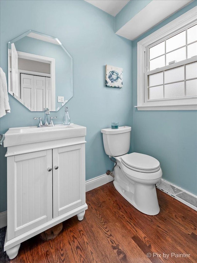 bathroom featuring vanity, hardwood / wood-style flooring, and toilet