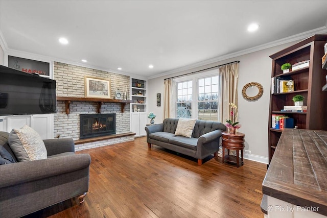 living room with crown molding, wood-type flooring, and built in shelves