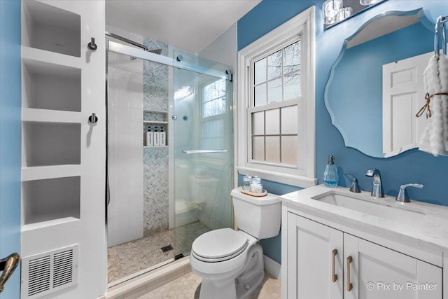 bathroom with a shower with door, vanity, and toilet