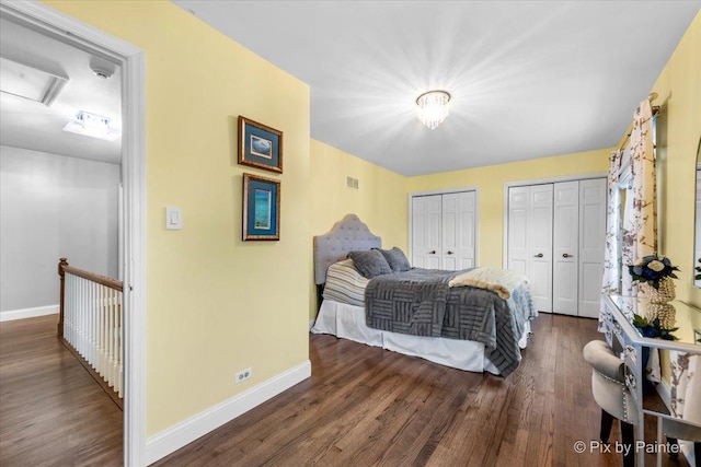 bedroom featuring multiple closets and dark hardwood / wood-style floors