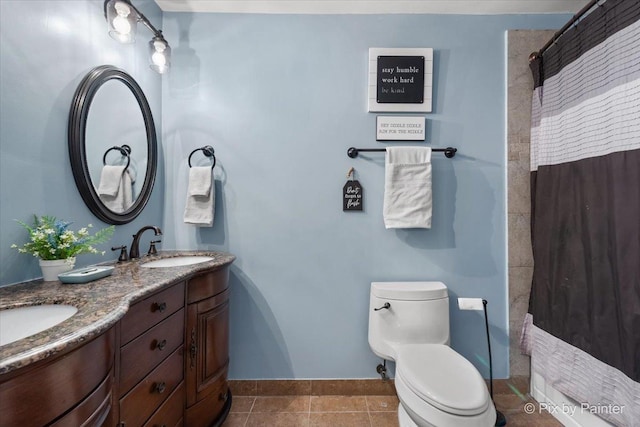 bathroom featuring tile patterned flooring, vanity, curtained shower, and toilet