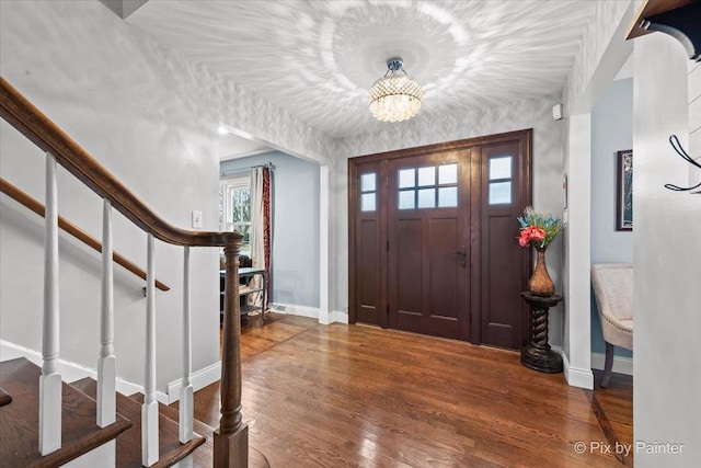 foyer with dark hardwood / wood-style flooring and a notable chandelier