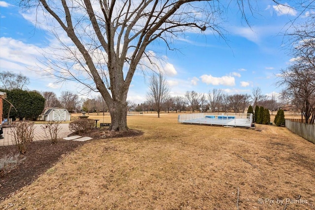 view of yard with a storage unit and a covered pool