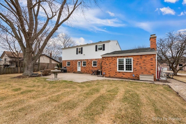 back of house featuring a lawn and a patio area