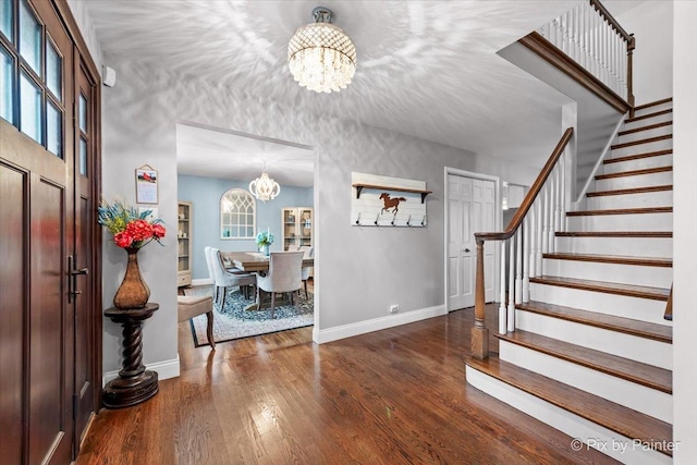 entrance foyer featuring dark hardwood / wood-style flooring and a chandelier