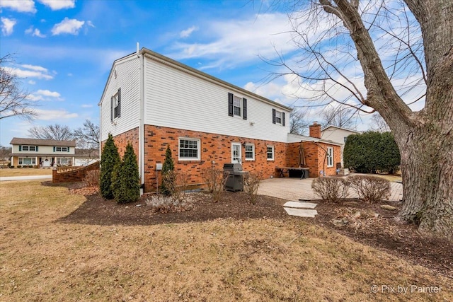 back of property featuring a patio and a lawn