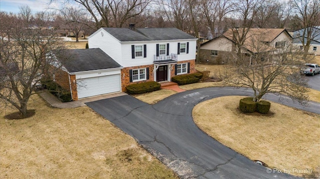 view of front of property with a balcony, a garage, and a front yard