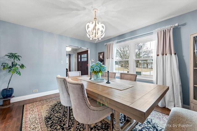 dining area featuring a notable chandelier and dark wood-type flooring