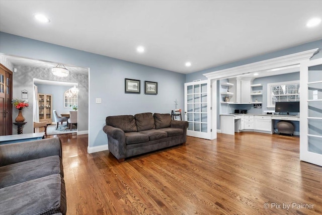 living room featuring french doors, built in desk, and light hardwood / wood-style flooring