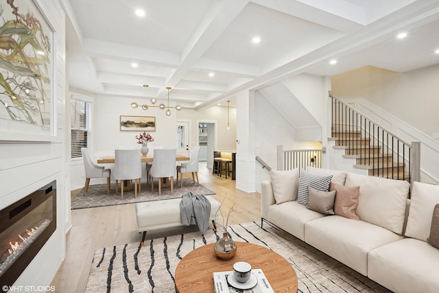 living room featuring beamed ceiling, coffered ceiling, and light wood-type flooring