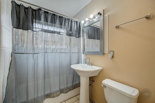 full bathroom with shower / tub combo with curtain, tile patterned floors, toilet, and sink