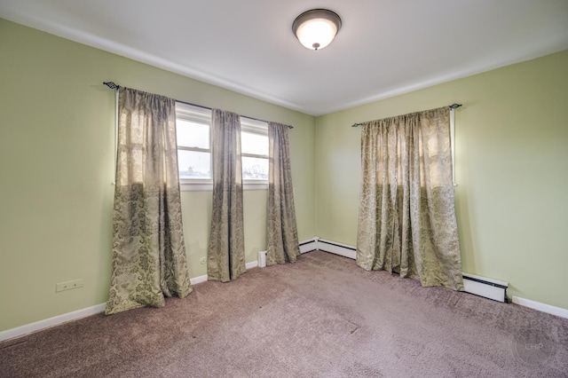 carpeted spare room featuring a baseboard heating unit