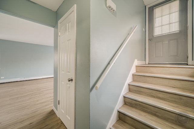 staircase with hardwood / wood-style flooring and a baseboard radiator