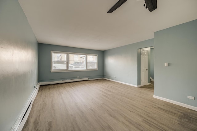 empty room featuring a baseboard heating unit, light hardwood / wood-style floors, and ceiling fan