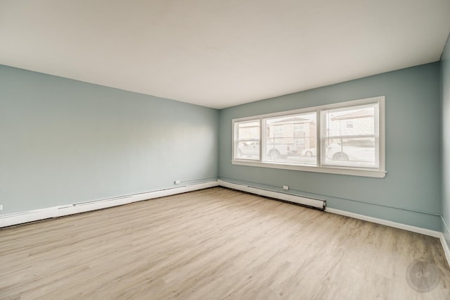 empty room featuring light hardwood / wood-style flooring and a baseboard radiator