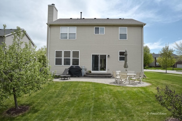 back of house with a lawn and a patio