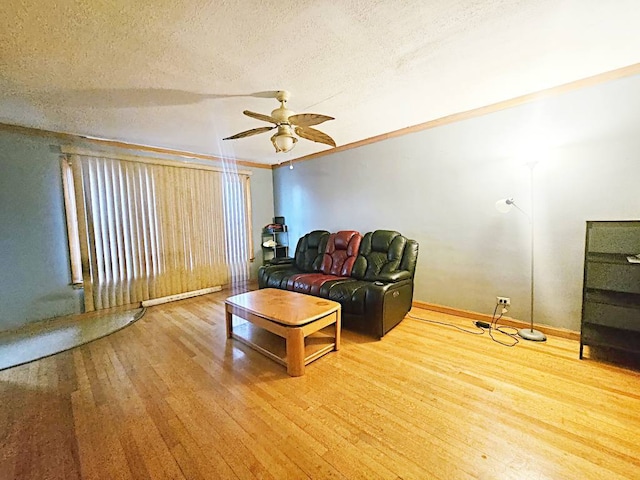 living room featuring wood-type flooring, crown molding, ceiling fan, and a textured ceiling