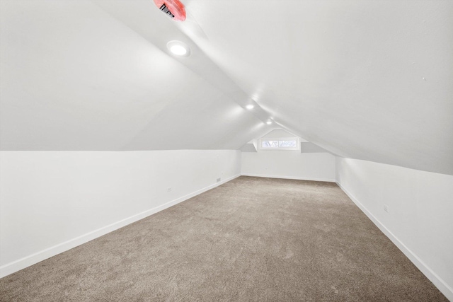 bonus room with lofted ceiling and carpet