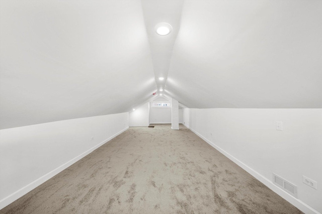 bonus room featuring vaulted ceiling and light carpet