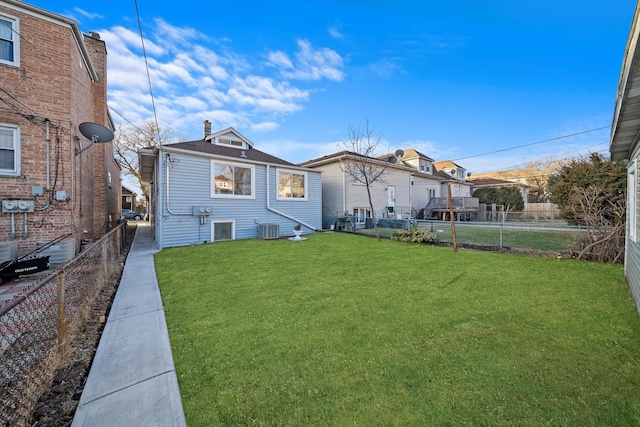 back of property featuring central AC and a lawn