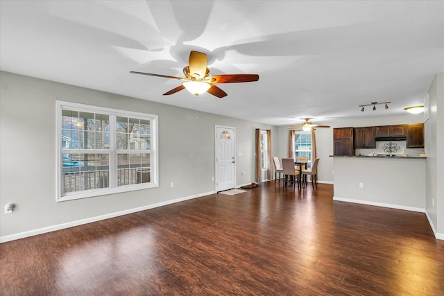 unfurnished living room with dark wood-type flooring and ceiling fan